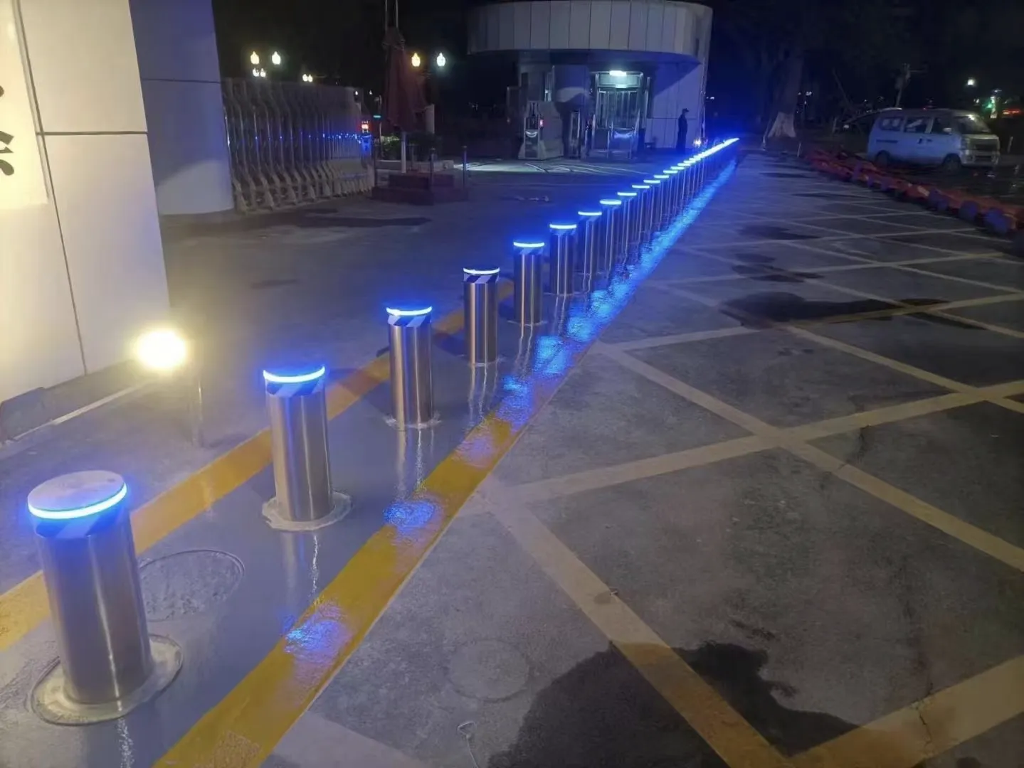 Elegantné zabezpečenie vjazdu – riad nerezových hydraulických stĺpikov s modrou LED signalizáciou pre moderný a prestížny vzhľad areálu